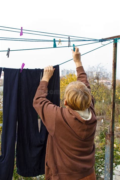 Laundry Woman Hangs Clean Wet Cloth On Clothes Dryer After Washing At