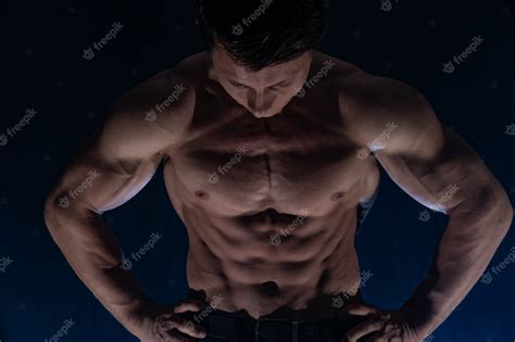 Мускулистый мужчина показывает мышцы изолированные на черном фоне здоровый образ жизни
