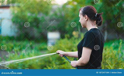 Woman Watering The Garden From Hose Female Spraying Water On Vegetables With A Garden Hose
