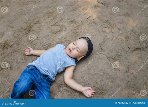 Little Boy Laying On Ground Pretending Sleep Or Unconscious Stock Photo