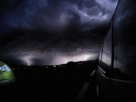 Black Car On The Road Under The Storm Clouds During The Lightning At