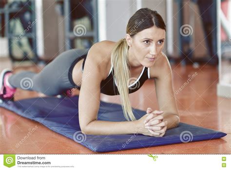 做在健身房的俏丽的微笑的健身教练员俯卧撑 行使在增氧健身班的年轻女运动员 医疗保健和重量lo 库存图片 图片 包括有 生活方式 运动