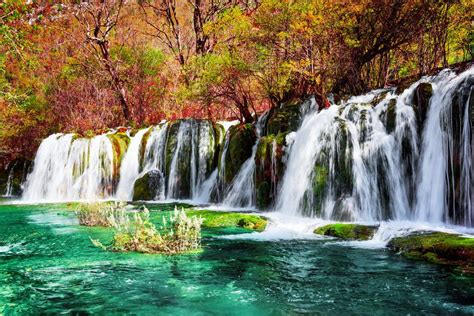 Beautiful Waterfall And Azure Lake With Crystal Clear Water Among Fall