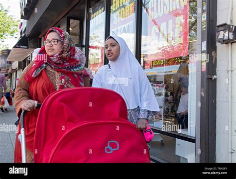 Two Muslim Women In Hijabs Probably Sisters Walk Down 74th St In Jackson Heights Pushing A