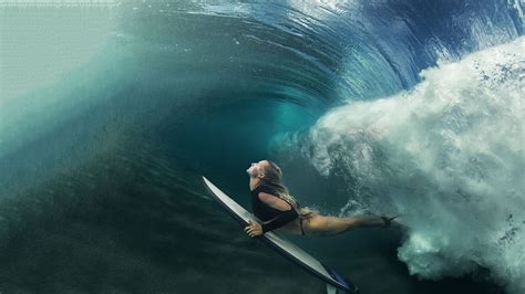 A Blonde Surfer Girl Underwater Doing Duck Dive Holding Surfing Bob