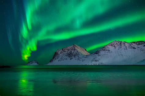 Puff Northern Lights Over Snowy Mountains And Sea In