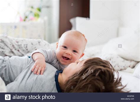 Two Children Baby And His Older Brother In Bed In The Morning Playing