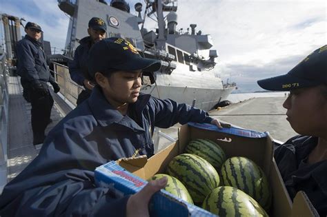 Sailor Carries Supplies Aboard Uss Ross During A Scheduled Port Visit
