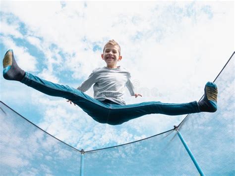 Boy Jumping On Trampoline Open Legs Stock Photo Image Of Action