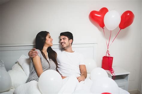 Free Photo Man Embracing His Girlfriend In Bed Surrounded By Balloons