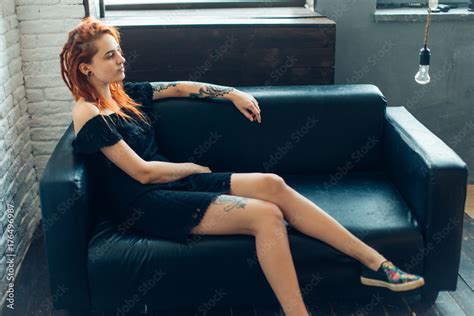 Curvy Raven Haired Redhead Woman With Dreadlocks And Tattoo Poses On Sofa Stock Foto Adobe Stock
