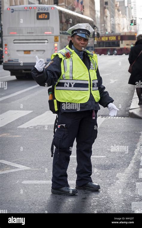 A Female Traffic Cop Directing Traffic On Fifth Avenue In Midtown