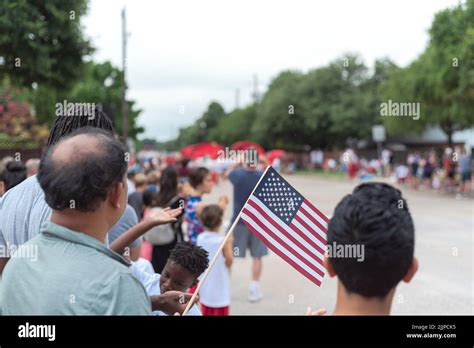 Diverse People Waving American Flags Watching Street Parade On July 4th