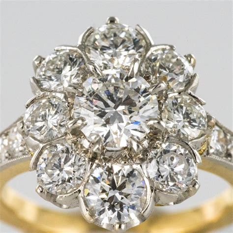 The diamond is usually set in an unadorned metal band, but some styles include a beautiful feature of diamonds set along the ring band for extra sparkle. Antique French Diamond Daisy Cluster Engagement Ring For Sale at 1stdibs