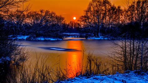Sunset In Winter Snow River Coast Two Sun Orange Sky Reflection In Water Beautiful Scenario
