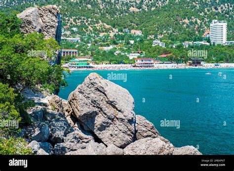 A Rocky Shore Above The Sea And A Resort Town With A Beach In The Background Rest In Crimea