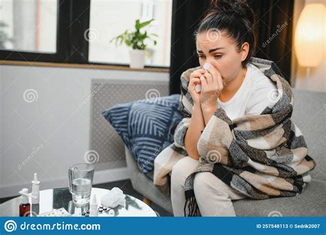 Ill Young Woman Sit On Sofa Covered With Blanket Freezing Blowing Her