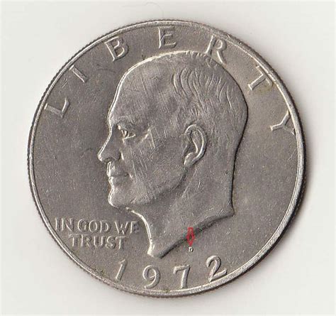 A Close Up Of A Silver Coin With A Red Marker On The Front And Side