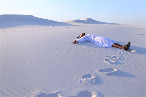 Happy Male Arab Lies Along White Sand Desert And Rejoices In New Stock
