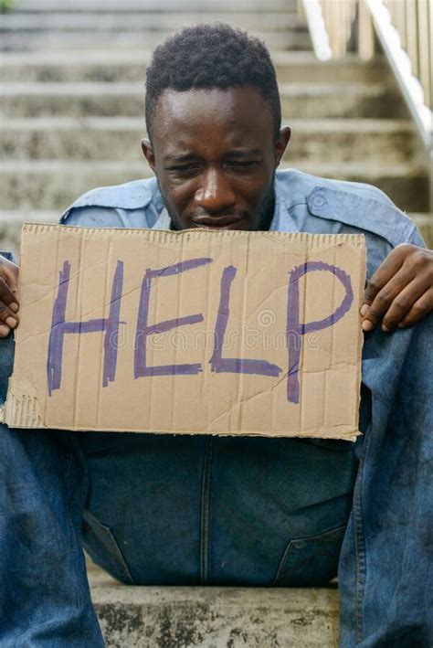 Depressed Young Homeless African Man With Cardboard Sign Asking For