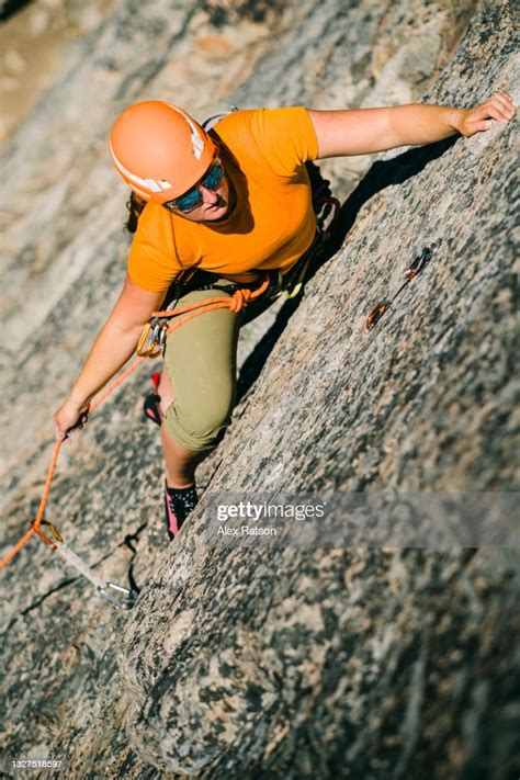 Female Rock Climber Pulls A Bite Of Rope Up In Her Hand While Lead