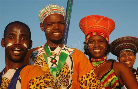 A Group Of People Standing Next To Each Other Wearing Headgear And Scarves