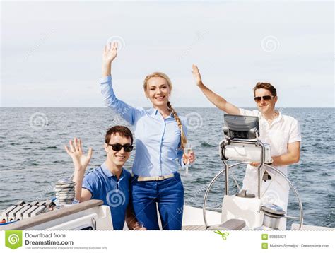 Group Of Happy Friends Having A Party On A Yacht And Drinking Ch Stock