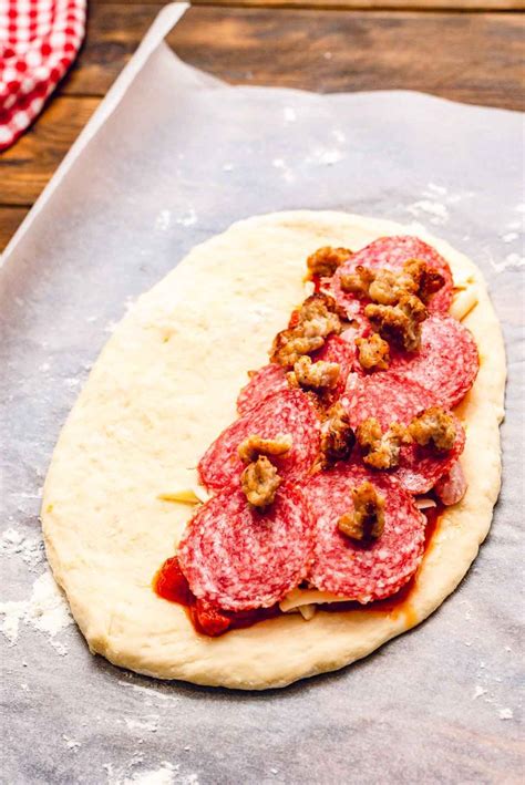 A Pizza Dough With Meat And Sauce On It