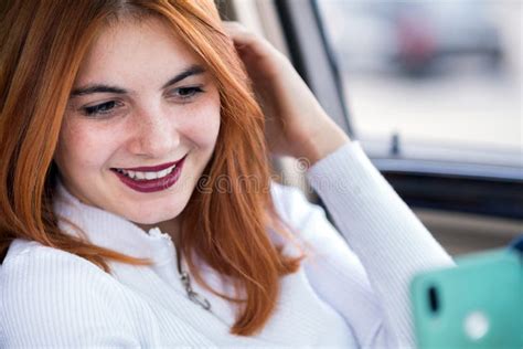 Young Redhead Woman Driver Taking Selfies With Her Mobile Phone Sitting