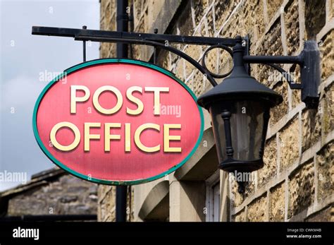 Traditional Post Office Sign And Old Style Lamp On Stone Walled