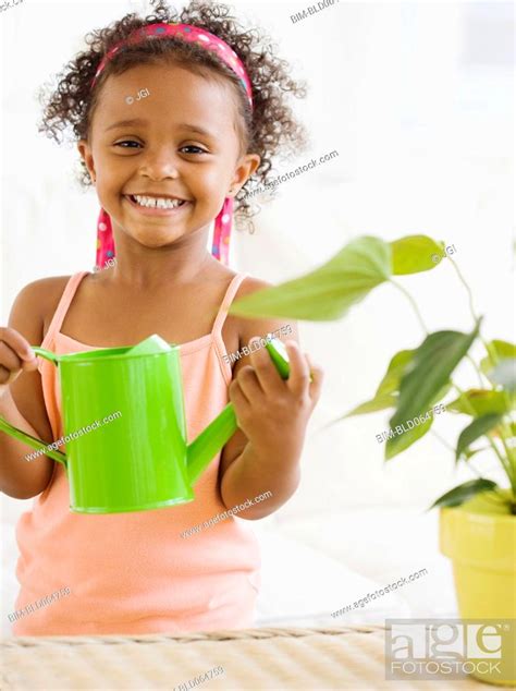 Mixed Race Girl Watering Plants Stock Photo Picture And Royalty Free