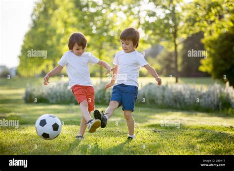Two cute little kids, playing football together, summertime. Children ...