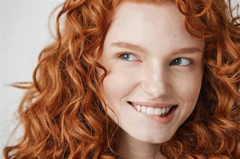 Free Photo Close Up Of Beautiful Girl With Curly Red Hair And Freckles Smiling Biting Lip