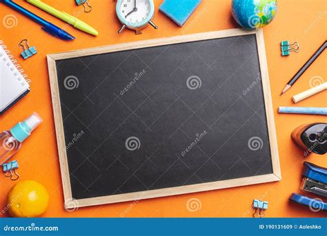 Stationery School Supplies Around The Board On A Orange Background