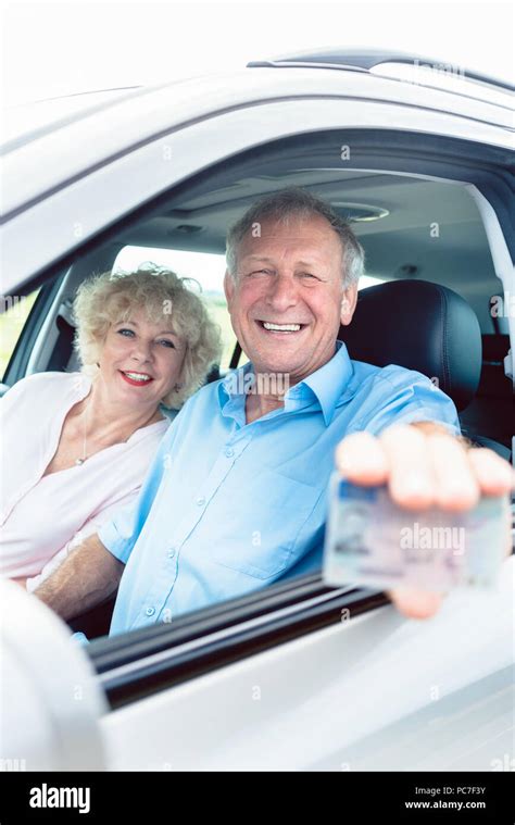 Portrait Of A Happy Senior Man Showing His Driving License Stock Photo