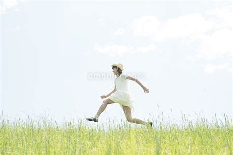草原を走る女性の写真素材 Fyi04548503 ストックフォトのamanaimages Plus
