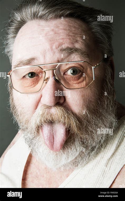 Senior Fat Old Man With A Full Beard And Glasses Sticking Out Tongue