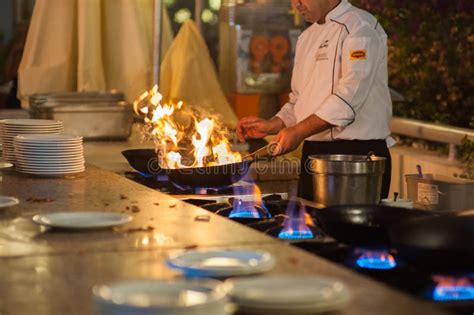 O Cozinheiro Prepara O Alimento No Calor Elevado Prato Quente Foto Editorial Imagem De Flama