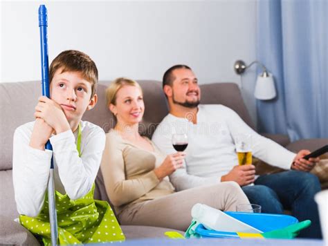 Sad Boy Tired After Cleaning With Carefree Parents Stock Image Image