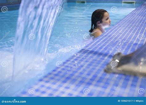 7 Years Little Girl Enjoying Waterfall Jets At Indoor Pool Spa Stock