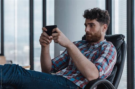 Man Watching Clips On His Phone By Stocksy Contributor MEM Studio