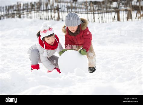 Happy Children Rolling Snowball Together Stock Photo Alamy