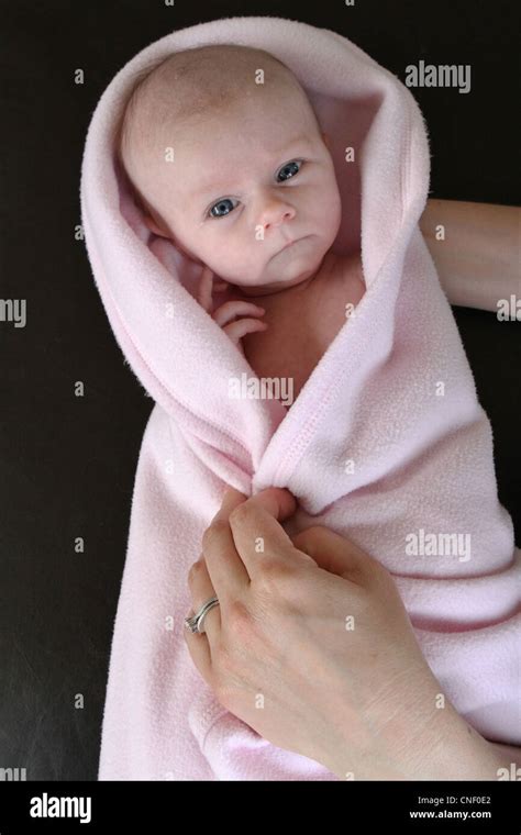 A Newborn Baby Girl Wrapped In A Pink Blanket Being Held Stock Photo