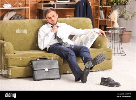 Businessman Taking Off His Shoes At Home After Long Working Day Stock
