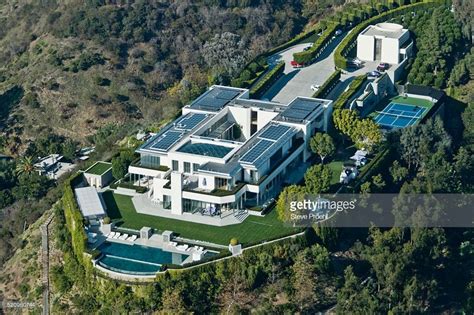 An Aerial View Of The House With Solar Panels On It S Roof And Swimming