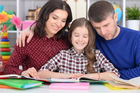 Parents Helping Their Children To Do Their Homework In The Classroom