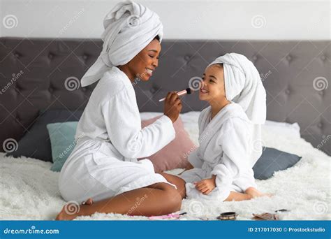 Happy Black Mom And Her Cute Daughter Wearing Bath Robes And Towels