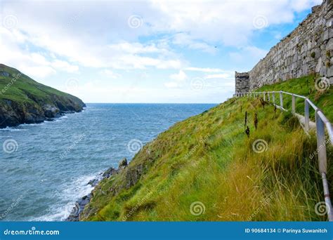 Coastline With Green Grass And Great Wall Of Peel Castle In Peel Isle