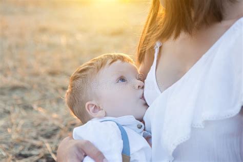 Beautiful Happy Mother Breastfeeding Her Baby Boy Outdoor Stock Photo