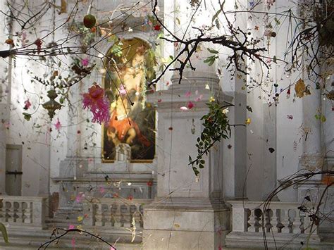 A Statue In The Middle Of A Room With Lots Of Flowers And Branches